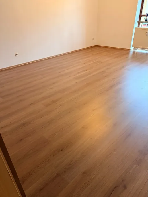 Frisch verlegter Laminatboden in einem leeren, renovierten Raum